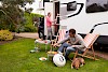 Heute gibt es lecker Wurst Beim grillen vor dem Wohnwagen mit Hund - © stock.adobe.com / micromonkey / #76946415